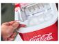 Eine Hand schöpft Eiswürfel aus einer roten Coca-Cola Eiswürfelmaschine.