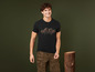 Mann in schwarzem T-Shirt mit Bergmotiv und Camouflagehose.