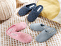 Ein Paar blaue Pantoffeln mit Muster und drei Paar rosa und graue Pantoffeln der Marke Esmara.