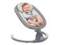 Lächelndes Baby in einer grau-weißen Babywippe mit Sicherheitsgurt.