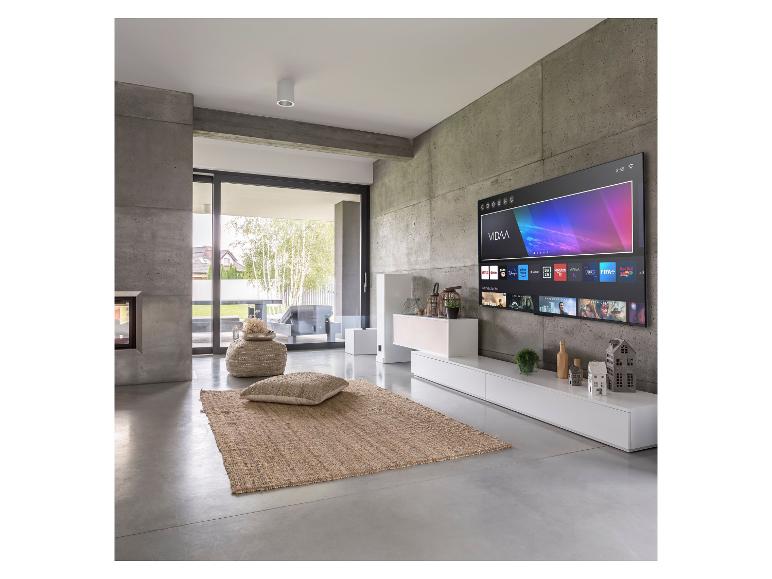 Modernes Wohnzimmer mit Fernseher, Kamin, Schiebetüren und Jute-Teppich.