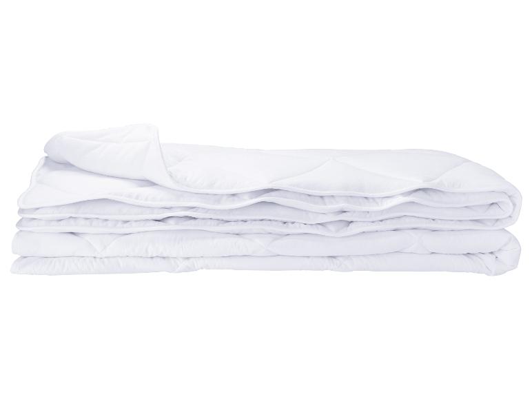 Eine weiße Bettdecke, zusammengefaltet vor weißem Hintergrund.