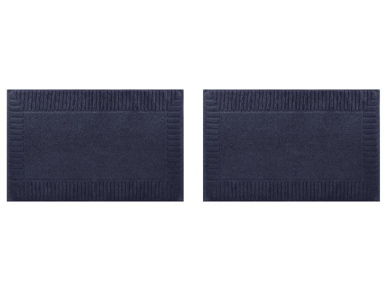 Zwei marineblaue Badematten mit strukturiertem Randmuster.