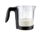 Messbecher mit Milch, mit Maßeinheiten in ml und Tassen.