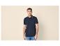 Mann in marineblauem Poloshirt mit blauen Streifendetails und Jeans.