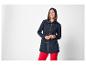 Lächelnde Frau in marineblauer Parka und roter Hose