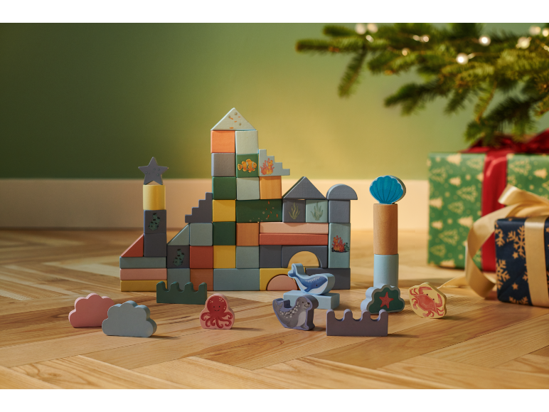 Holzbausteine mit Meeresthema und Tierfiguren, mit Geschenken unter dem Weihnachtsbaum.