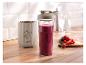 SilverCrest Smoothie-Maker mit Flasche voller fruchtigem Smoothie und frischem Obst auf einem Holzbrett.