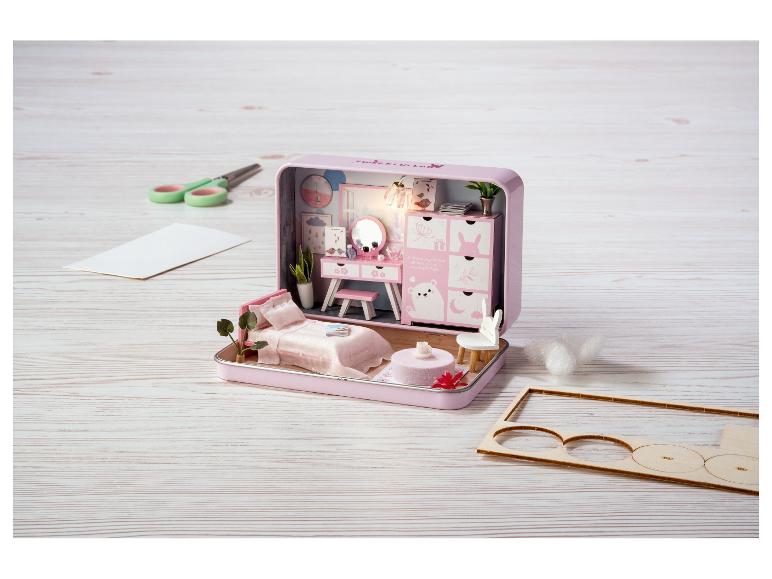 Ein rosafarbenes Sweet Lullaby Miniatur-Puppenhaus mit Möbeln und Bastelmaterialien.