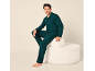 Mann in grünem Karo-Pyjama sitzt auf einem weißen Hocker.