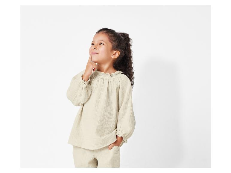 Beigefarbene Kinderkleidung, Oberteil und Hose, lässiger Stil.