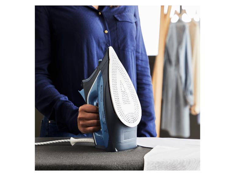 Eine Person hält ein Rowenta Bügeleisen auf einem Bügelbrett mit einem weißen Hemd.