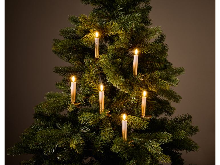 Künstlicher Weihnachtsbaum mit leuchtenden LED-Kerzen auf dunklem Hintergrund.