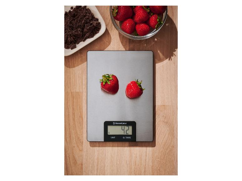 SilverCrest Küchenwaage mit Erdbeeren, daneben eine Schale Erdbeeren und gehackte Schokolade.