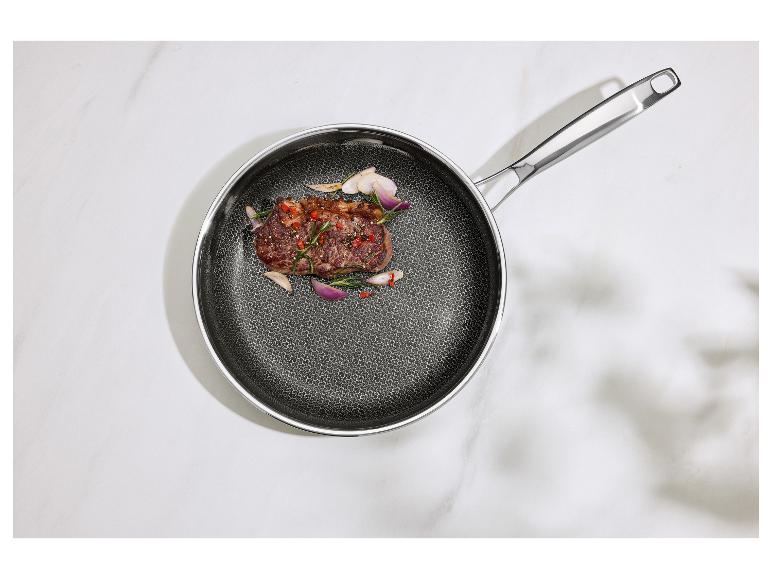 Bratpfanne mit einem gekochten Steak, Rosmarin und Schalotten auf weißem Marmor.