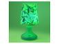 Grüne Tischlampe mit Lampenschirm, der mit Zeichentrickfiguren und Blättern gemustert ist.