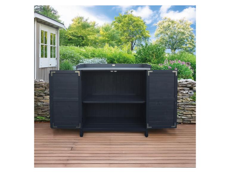 Dunkelgrauer Gartenschrank mit offenen Türen auf einer Holzterrasse, umgeben von Grünpflanzen.