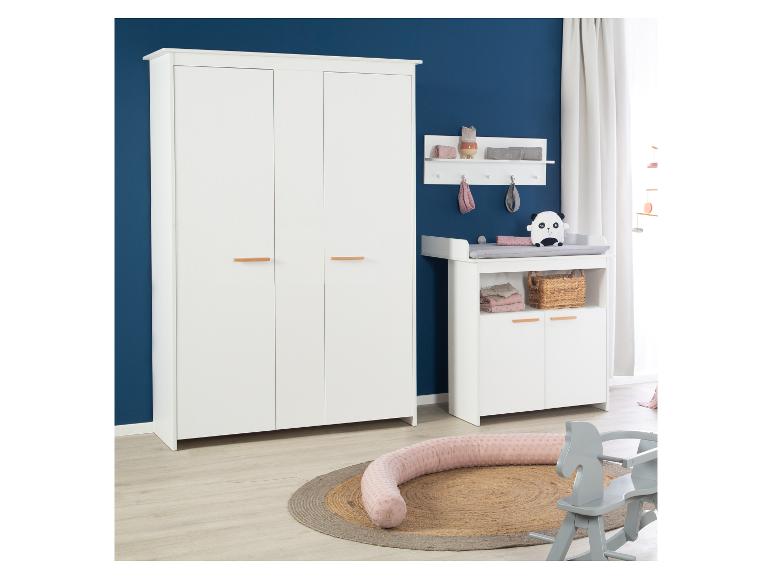 Weißes Babyzimmer mit Kleiderschrank, Wickeltisch und Spielzeug auf einem Teppich.