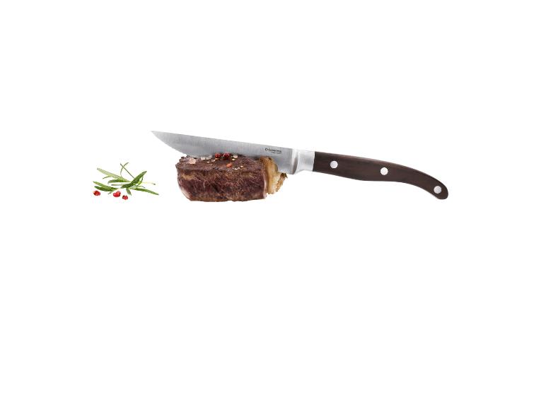 Steak mit Messer, Rosmarin und Pfeffer auf weißem Hintergrund.