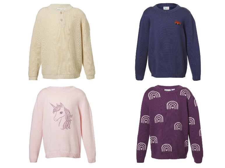 Vier Kinderpullover: ein cremefarbener Waffelstrick, ein marineblauer mit LKW, ein rosa mit Einhorn und ein lila mit Regenbögen.