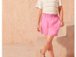 Eine rosa Shorts mit einem gestreiften T-Shirt.
