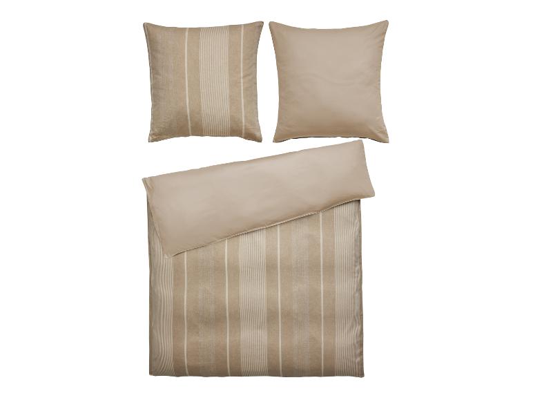 Ein beigefarbenes Bettbezug-Set mit gestreiften Kissenbezügen.