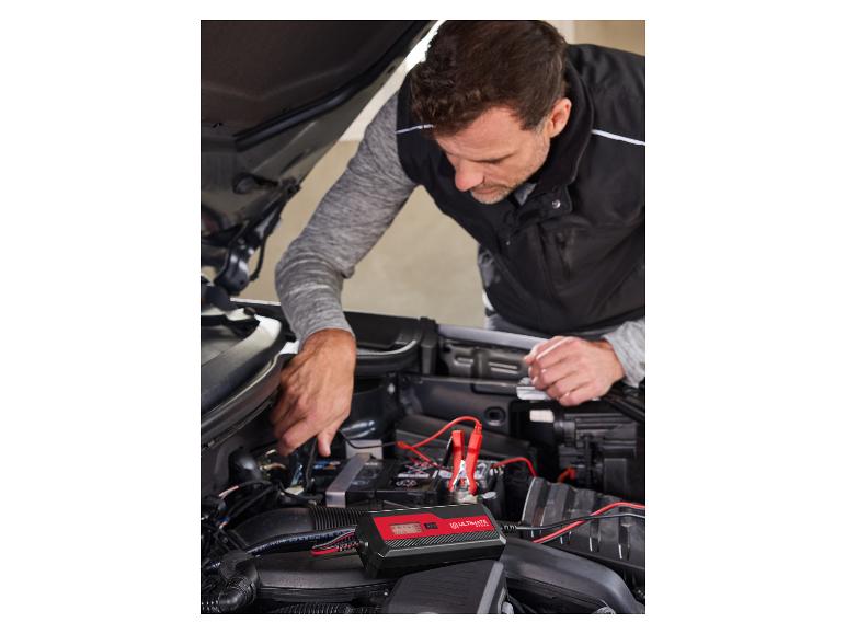 Mann schließt ein Ultimate Speed Batterieladegerät an ein Auto an.