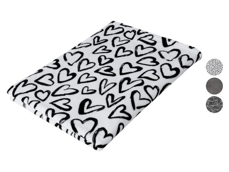 Weiße Decke mit schwarzen Herzen und drei runden Musterproben.