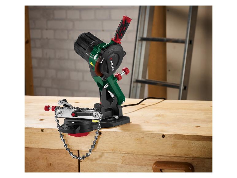 Elektrischer Kettenschärfer auf einer Holzwerkbank in einer Werkstatt.