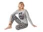 Frau in einem grauen Mickey Mouse Pyjama mit Punkten.