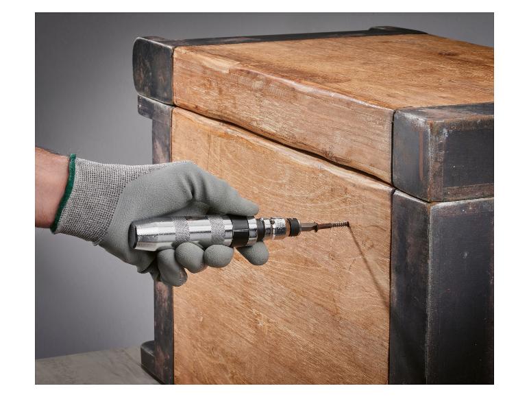 Ein Schlagschrauber wird an einer Holzkiste verwendet.