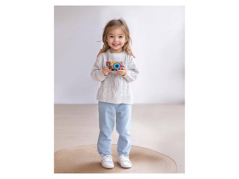 Kleines Mädchen mit einer Paw Patrol Spielzeugkamera.