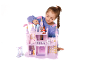 Mädchen spielt mit einem rosa Puppenhaus und Spielfiguren.