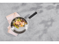 Lachsfilet mit Gemüse in einer Pfanne auf grauem Hintergrund.