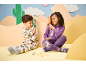 Zwei Kinder in Pyjamas mit Tiermotiven, halten Lupen und betrachten Spielzeuginsekten.