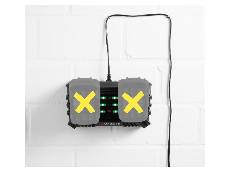 Ladegerät mit zwei Akkus an einer weißen Ziegelwand.