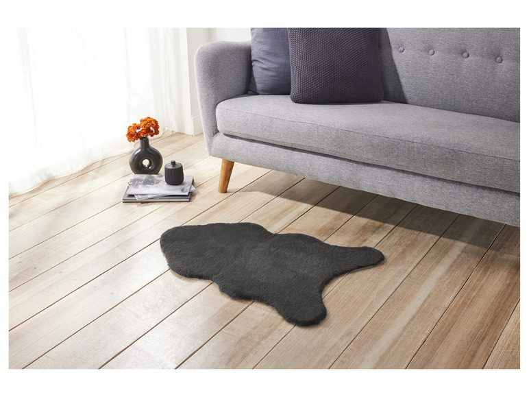 Ein grauer Teppich im Wohnzimmer neben einer grauen Couch.