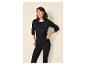 Frau in schwarzem Thermoshirt und Leggings, lächelnd und entspannt.