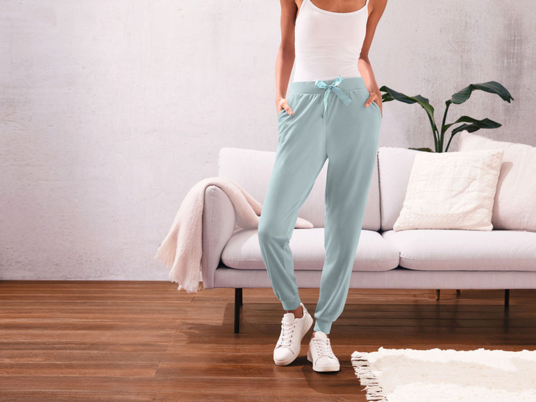 Frau trägt hellblaue Jogginghose und weiße Sneakers.