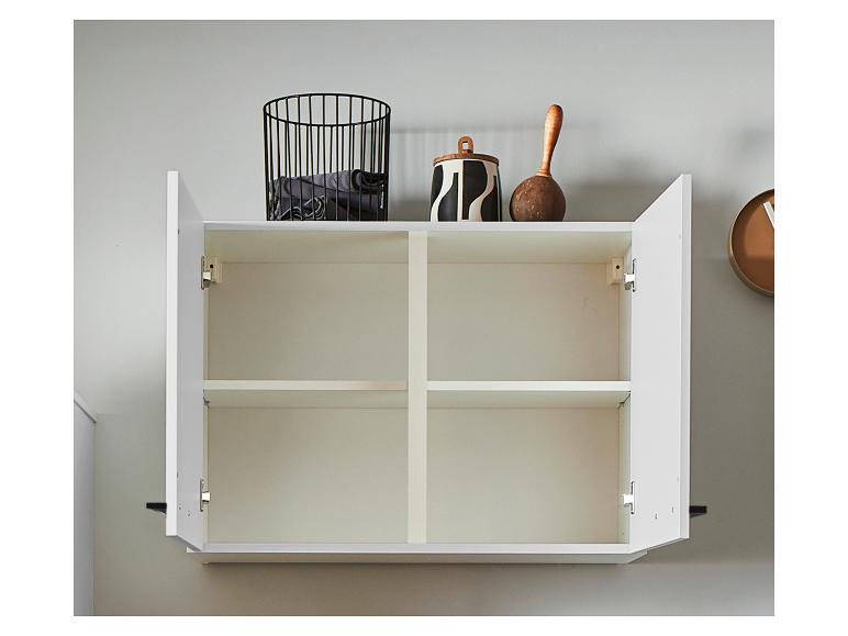 Weißer Wandschrank mit offenen Türen, schwarzem Drahtkorb und Dekoartikeln oben.