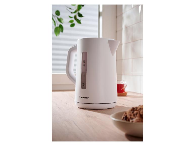 Weißer SilverCrest Wasserkocher auf einer Holztheke mit einer Tasse Tee.