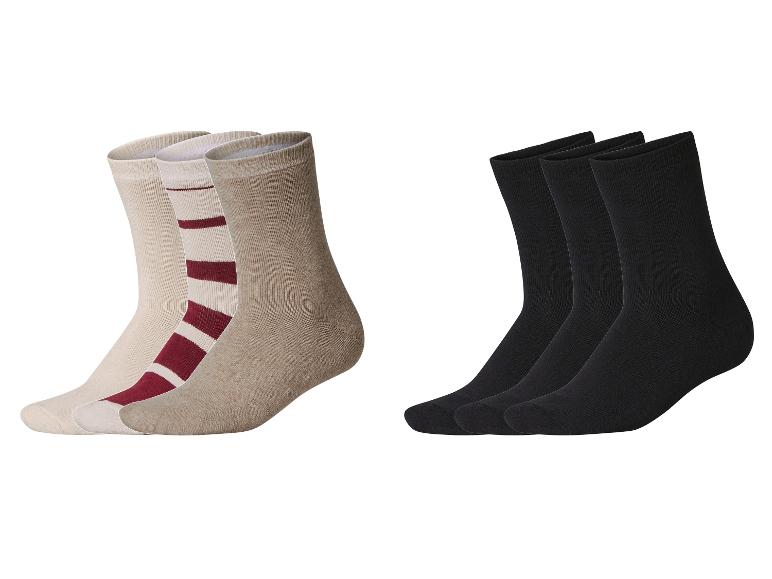 Drei Paar Socken: ein Set in Beige und Bordeauxrot gestreift, und ein weiteres Set in Unifarben Schwarz.