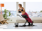 Frau macht Rückenübungen mit einer Kettlebell auf einer Trainingsbank.