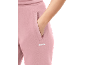 Nahaufnahme einer rosa Jogginghose mit einer Hand in der Tasche.