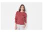 Eine Frau trägt einen roten Strickpullover mit kleinem Logo.