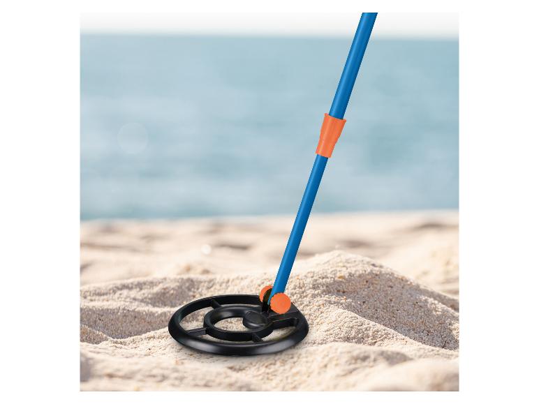 Metalldetektor an einem Sandstrand mit dem Meer im Hintergrund