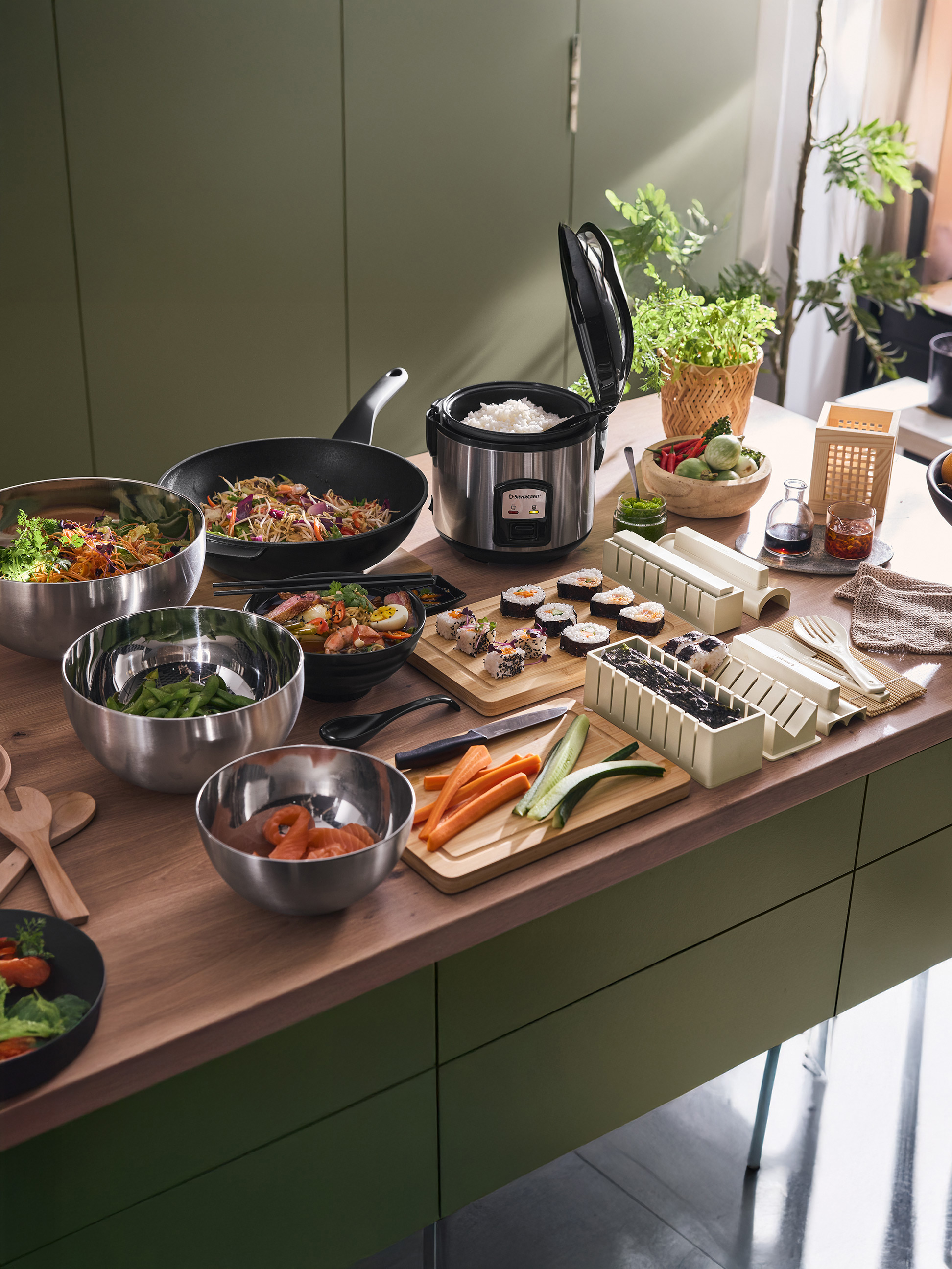 Asiatische Küche mit SilverCrest Reiskocher, Wok, Sushi und Salatschüsseln.