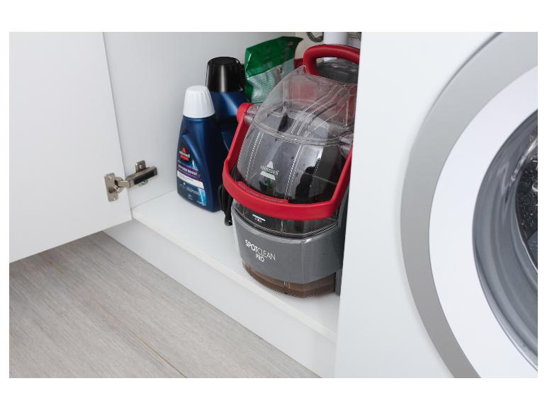 BISSELL SpotClean Pro Fleckenreiniger und Waschmittel in einem weißen Schrank neben der Waschmaschine.
