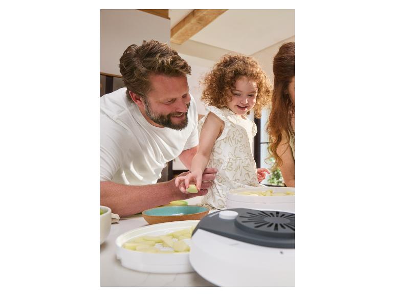 Familie trocknet Äpfel in einem Dörrautomat.