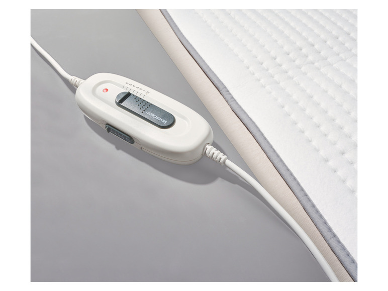 Ein weißes Heizkissen von Silvercrest mit einem Drehknopf.